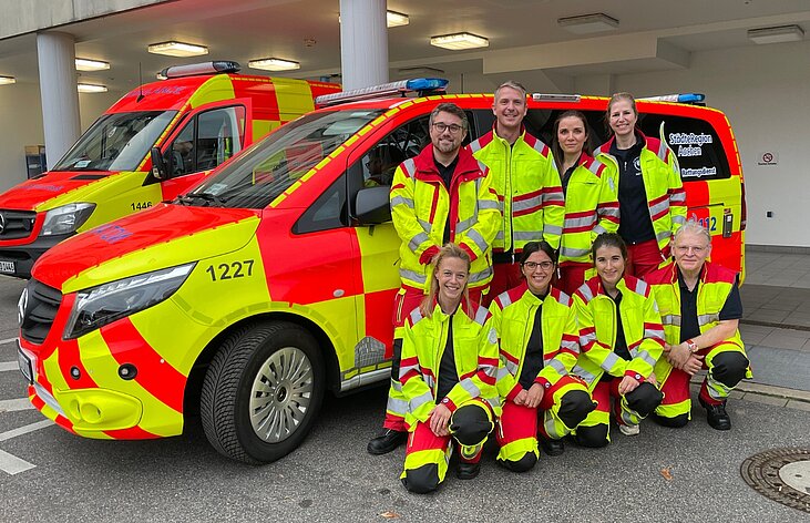 Notärzte-Team des St.-Antonius-Hospitals vor einem Einsatzwagen